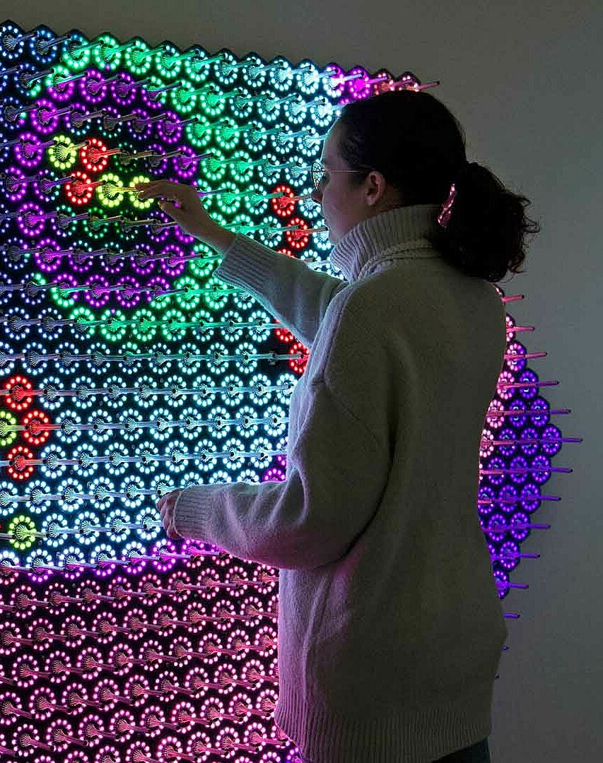 Frau vor der interaktiven Lichtwand "Quantum jungle", Brain City Berlin