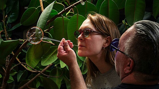 [Translate to en:] Frau experimentiert mit Glaskolben auf der LNDW 2024, Brain City Berlin